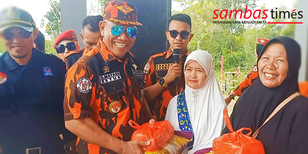 Ketua Pemuda Pancasila Kabupaten Sambas Mayadi Satar membagikan sembako kepada warga Desa Temajuk.
