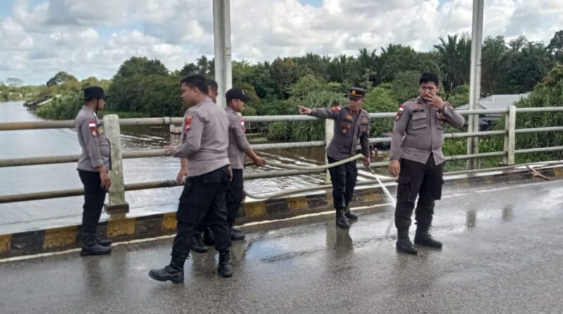 Personel Polres Sambas membersihkan tumpukan pasir di Jembatan Sabok, Rabu (7/12/2022).