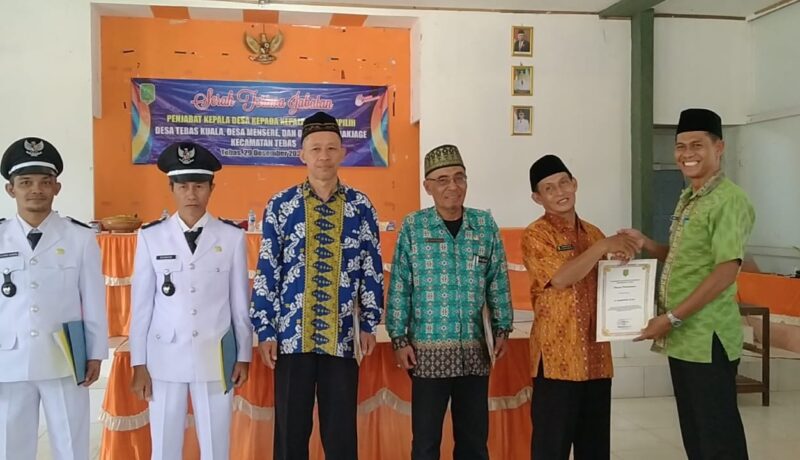 Camat Tebas Dedi Zulkarnain memberikan penghargaan kepada Pj Kades, Kamis (29/12/2022) di Gedung Serbaguna Kecamatan Tebas.