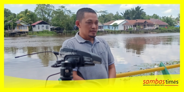 Dokumentasi foto Anggota DPRD Kalbar H Subhan Nur berlatar belakang Sungai Sambas Kecil saat diwawancarai salah satu media nasional.