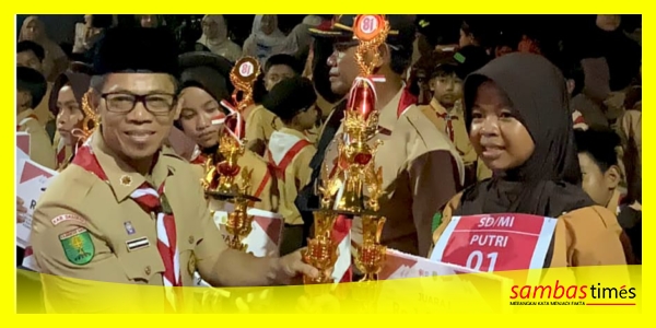 Pelajar SDN 28 Mutiara Indah menerima Piala Juara Pertama Lomba Pawai Obor yang diserahkan Kepala Dinas Sosial, DR Budi Iswanto mewakili Bupati Sambas H Satono, Sabtu malam. 
